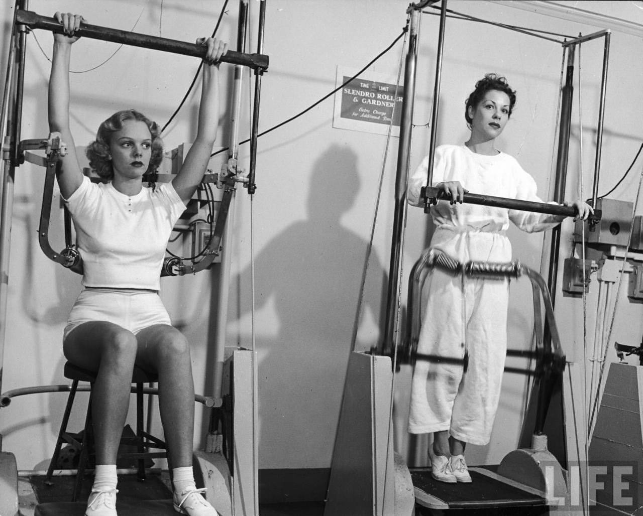 Model Pat Ogden (L) at slenderizing salon operating a Back Ring Roller designed to work on fatty parts of back from waist up. Ann Miller (R) using a modified Slendro Massager to reduce hips.