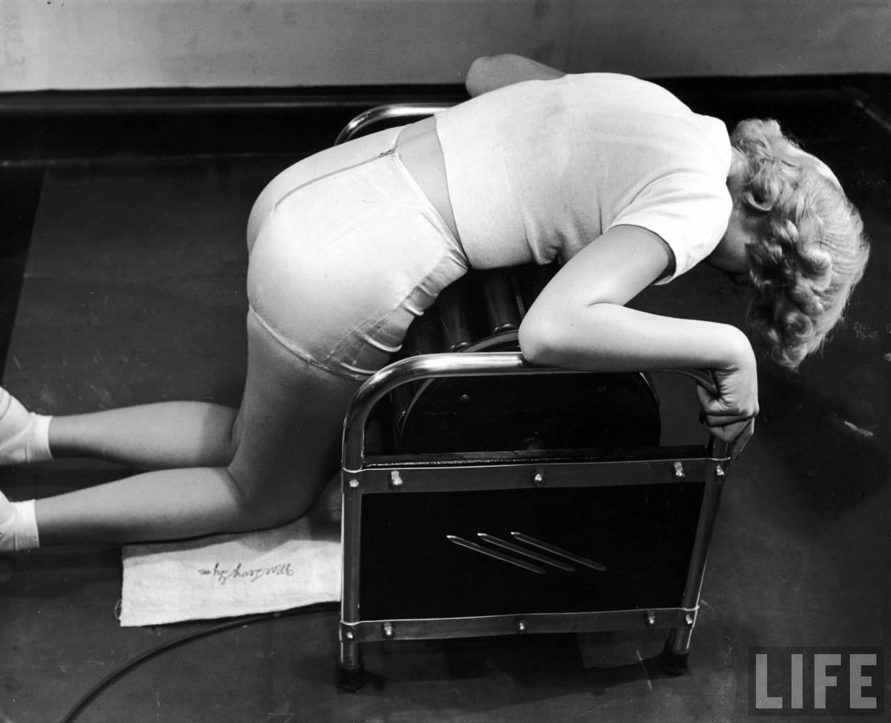 Model Pat Ogden at slenderizing salon undergoing abdomen massage on the Roaler Massager.