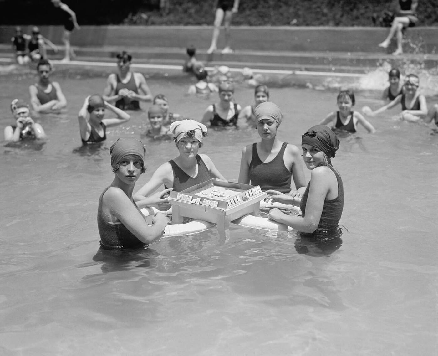 Four women playing mah-jong in water at a bathing beach, Washington DC, 1924.