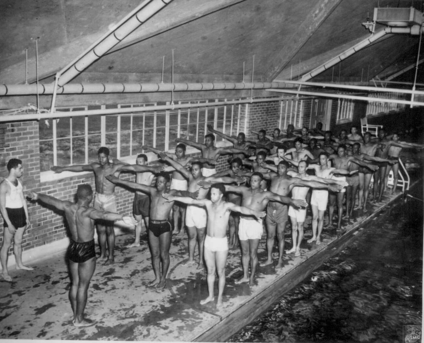 Marine Pfc. Paul Tolliver instructs leathernecks on the correct movements for the breaststroke at Montford Point, Camp Lejeune, N.C., 1944.