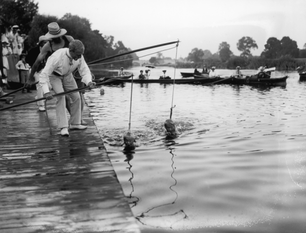 In 1906, the preferred method of teaching kids to swim looked a lot like fishing. These children are in the River Thames at Wallingford, kept afloat by ropes attached to poles.
