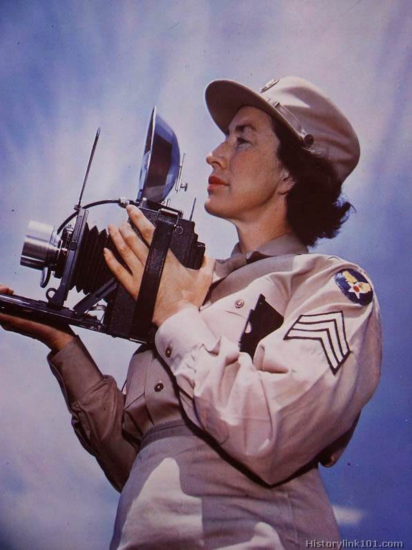 A WAC Sergeant makes a shot with a flash camera while in training.