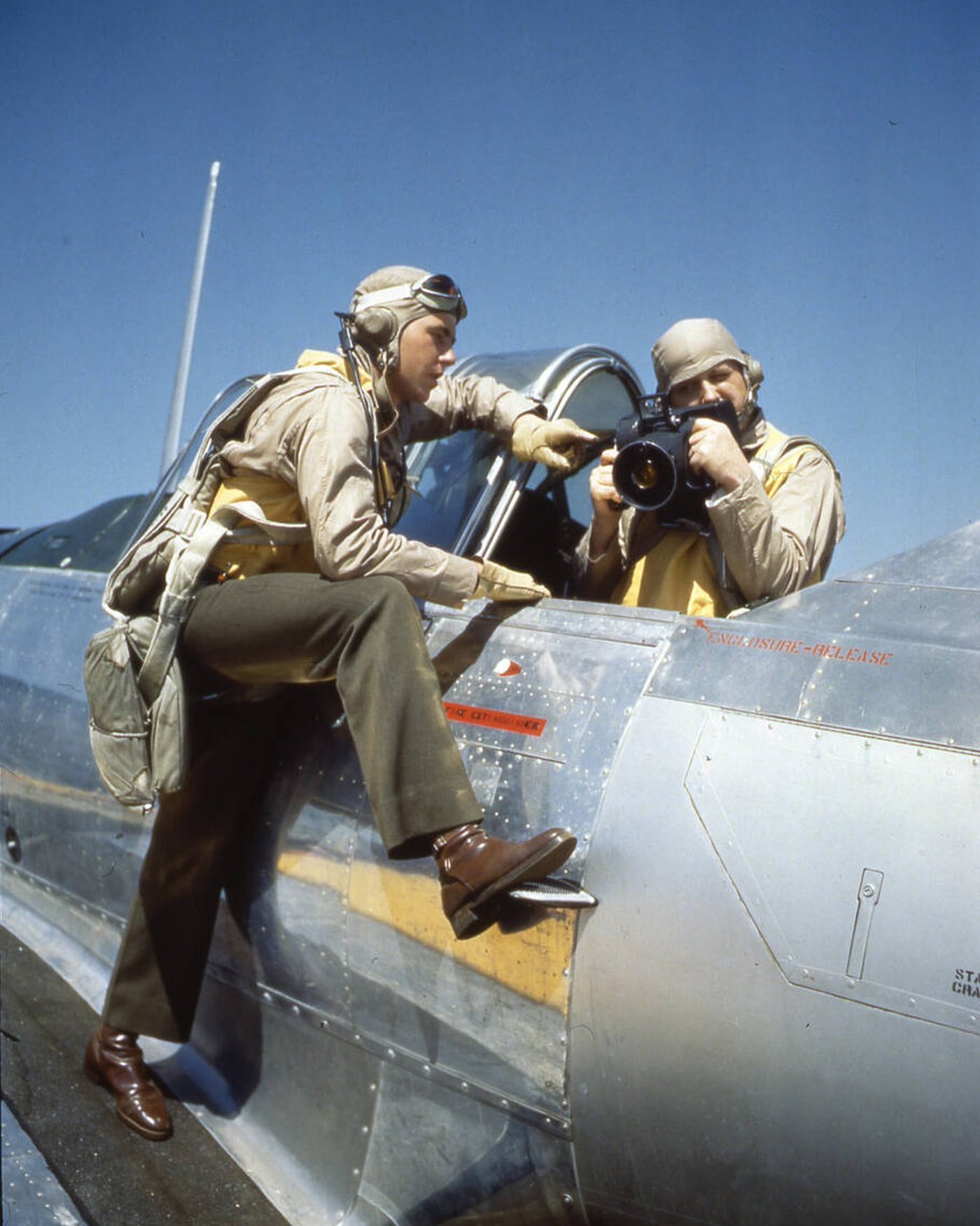 Pilot and student aerial photographer discuss a mission; plane is an SNJ trainer, 1944.