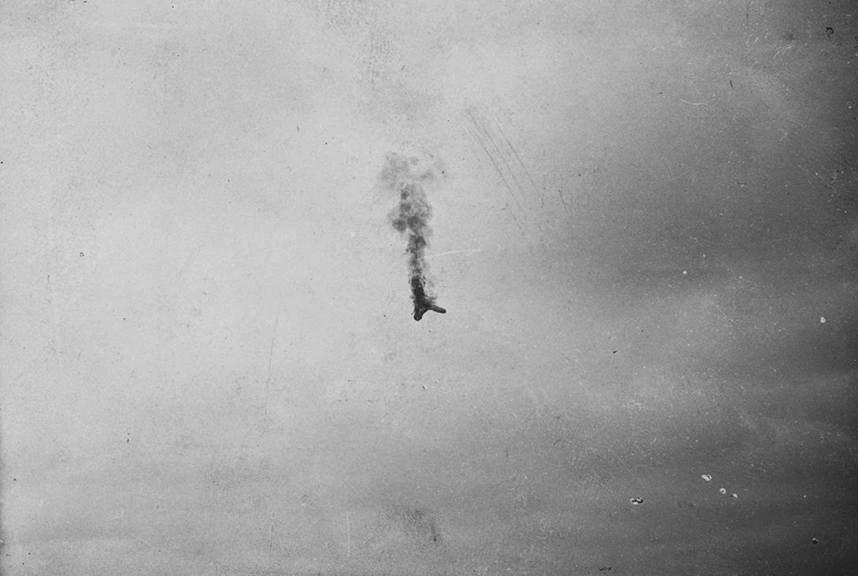 An aircraft in flames falls from the sky.