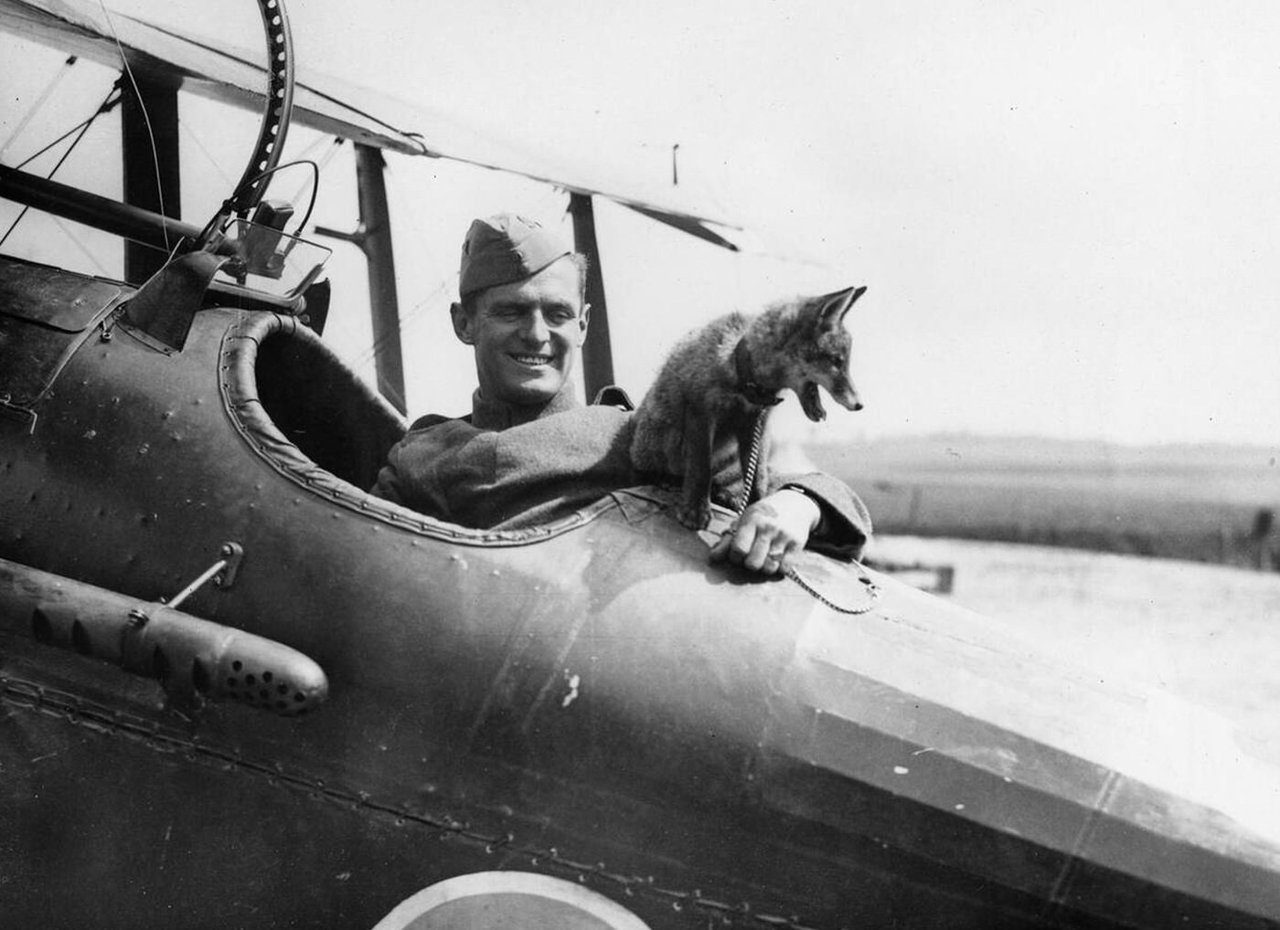 A pilot from World War I seated in a biplane of the Royal Flying Corps wearing early aviation gear, 1914-1918.