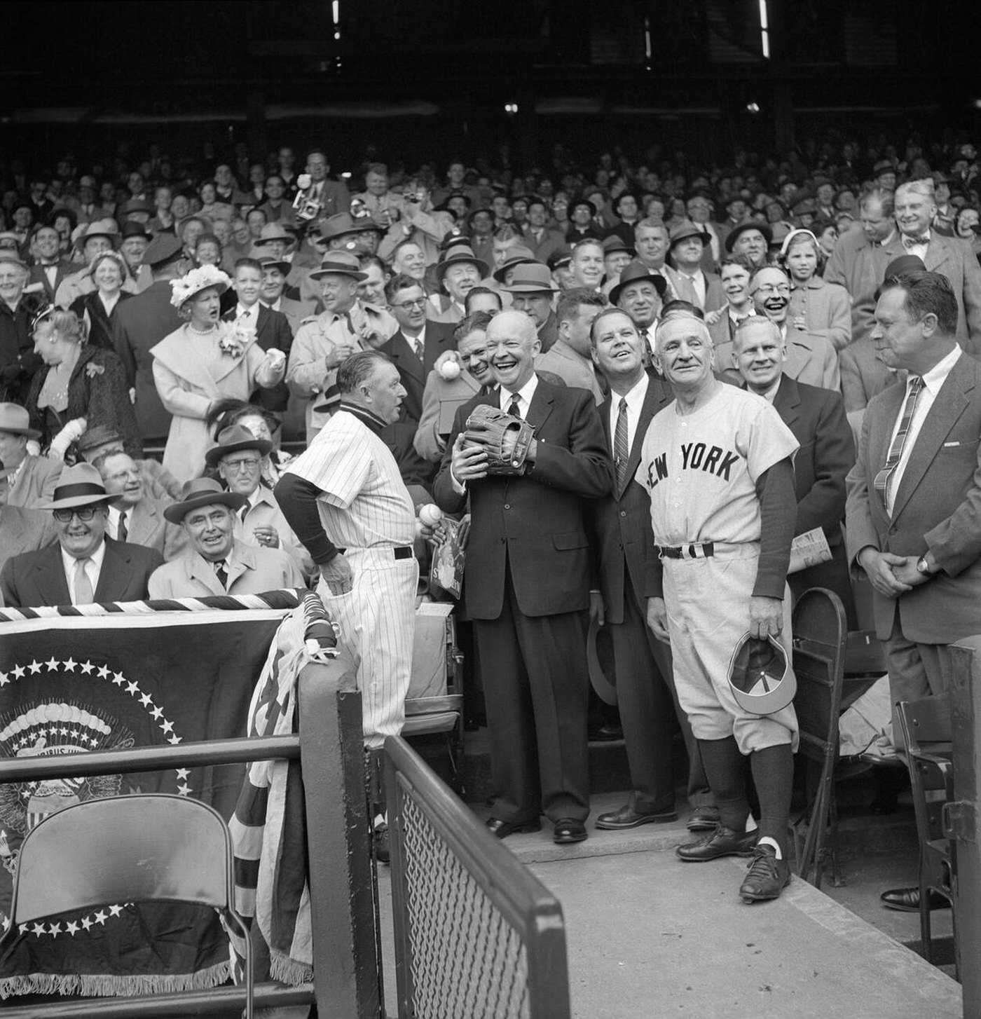 U.S. President Dwight Eisenhower getting ready to Toss out First Ball at Opening Day Baseball Game between Washington Senators and New York Yankees, with Yankees Manager Casey Stengel and Senators Manager Chuck Dressen, Washington, D.C., 1956.