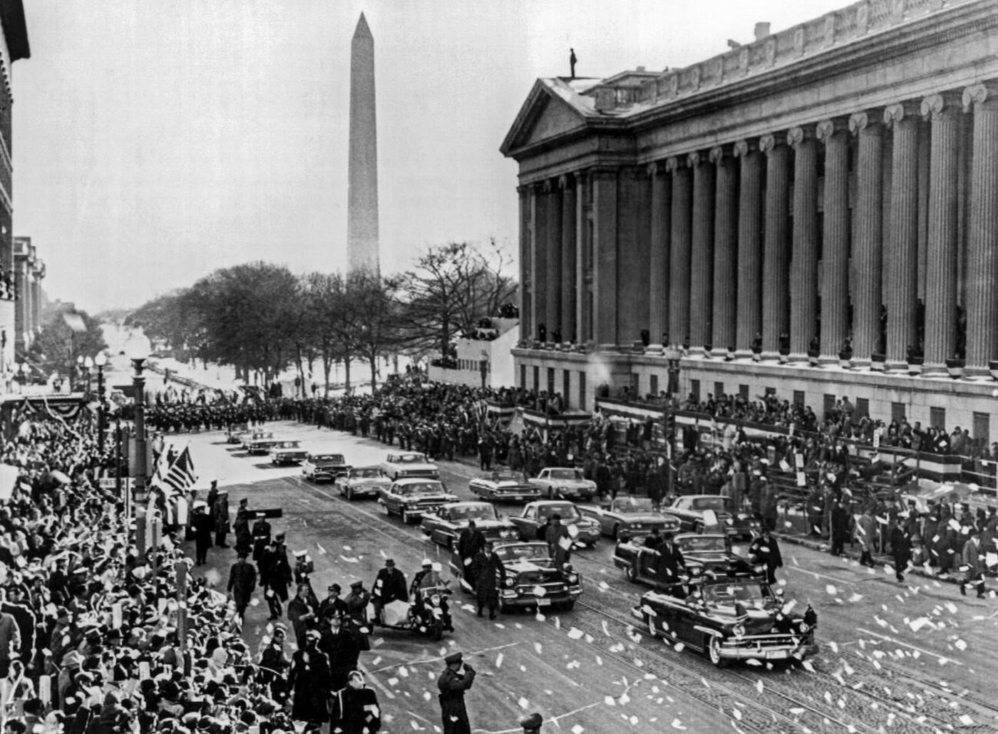 Newly inaugurated President and Mrs. Kennedy's car comes up 15th Street past the Treasury Department en route to the White House, Washington, D.C.