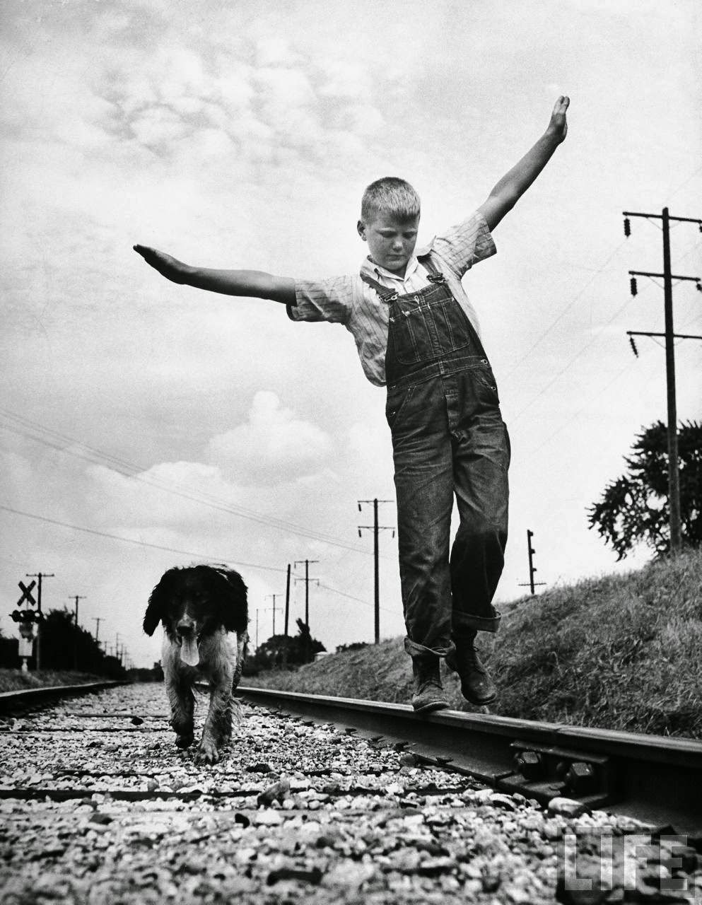 Tired and thoroughly dirty from a hard day's play, Dunk pads along the roadbed while Larry practices the delicate art of walking on rails.