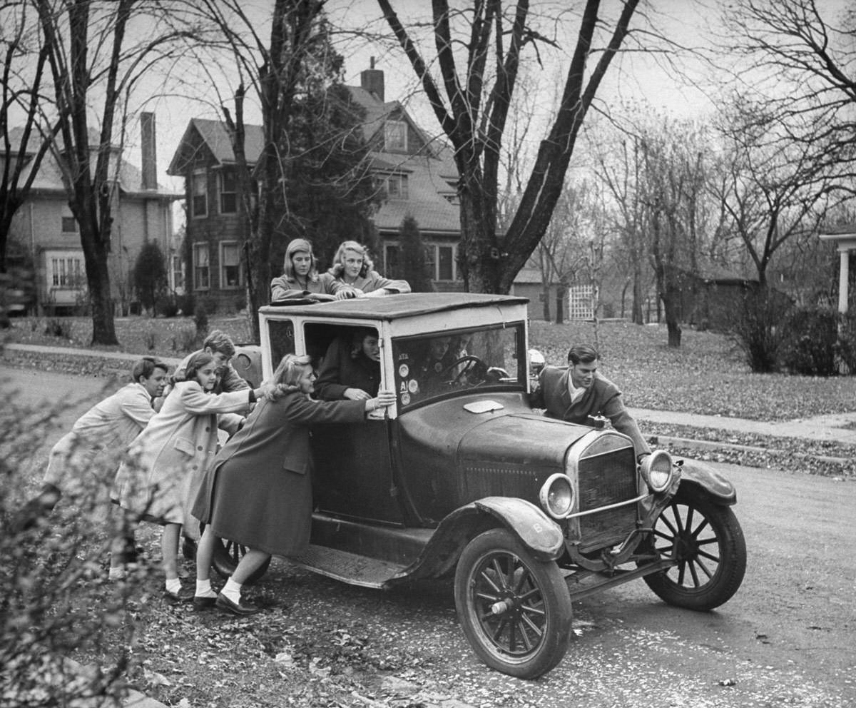Teenagers push a model T to get it started, 1940s