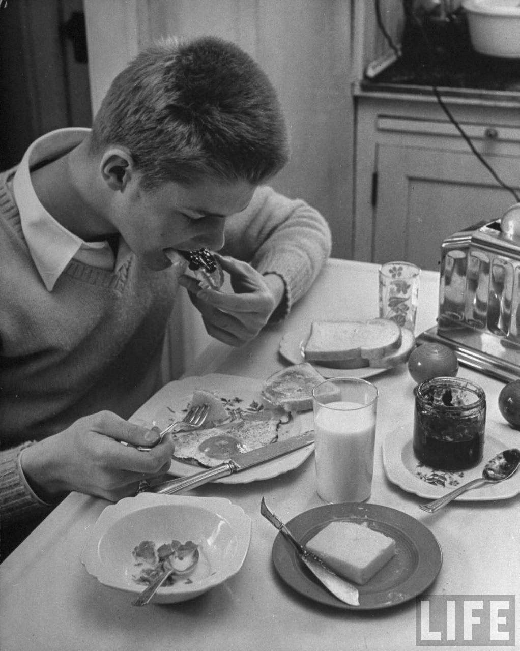 Teen-age boy eating large breakfast.