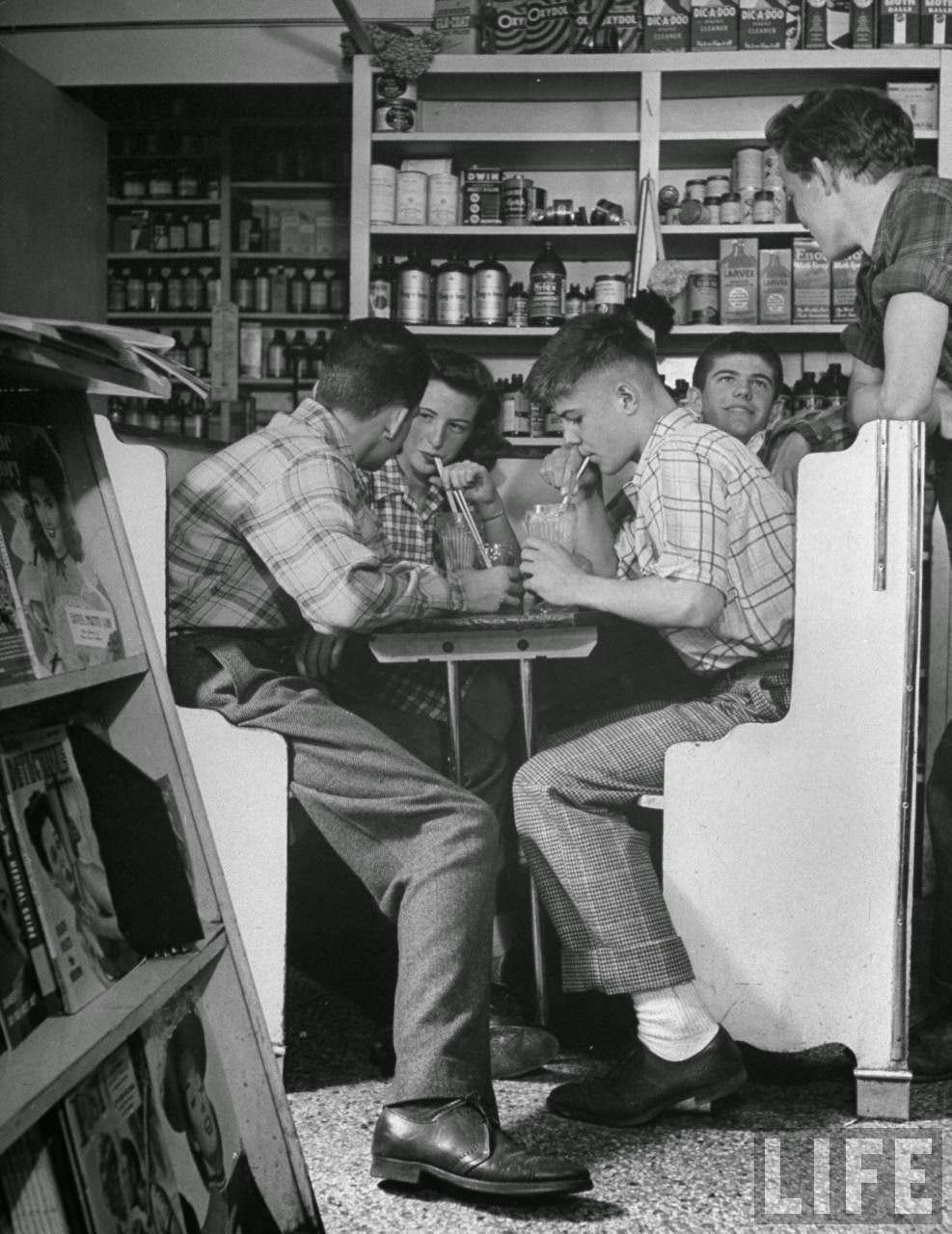 Teen-age boys and girls eating lunch and drinking milkshakes in drug store.
