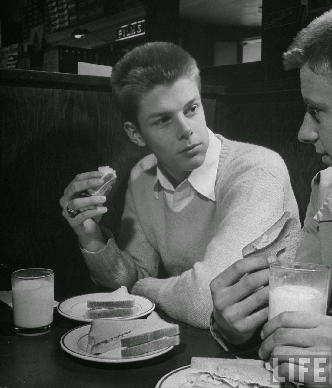 Teen-age boys eating lunch and drinking milk in drug store.