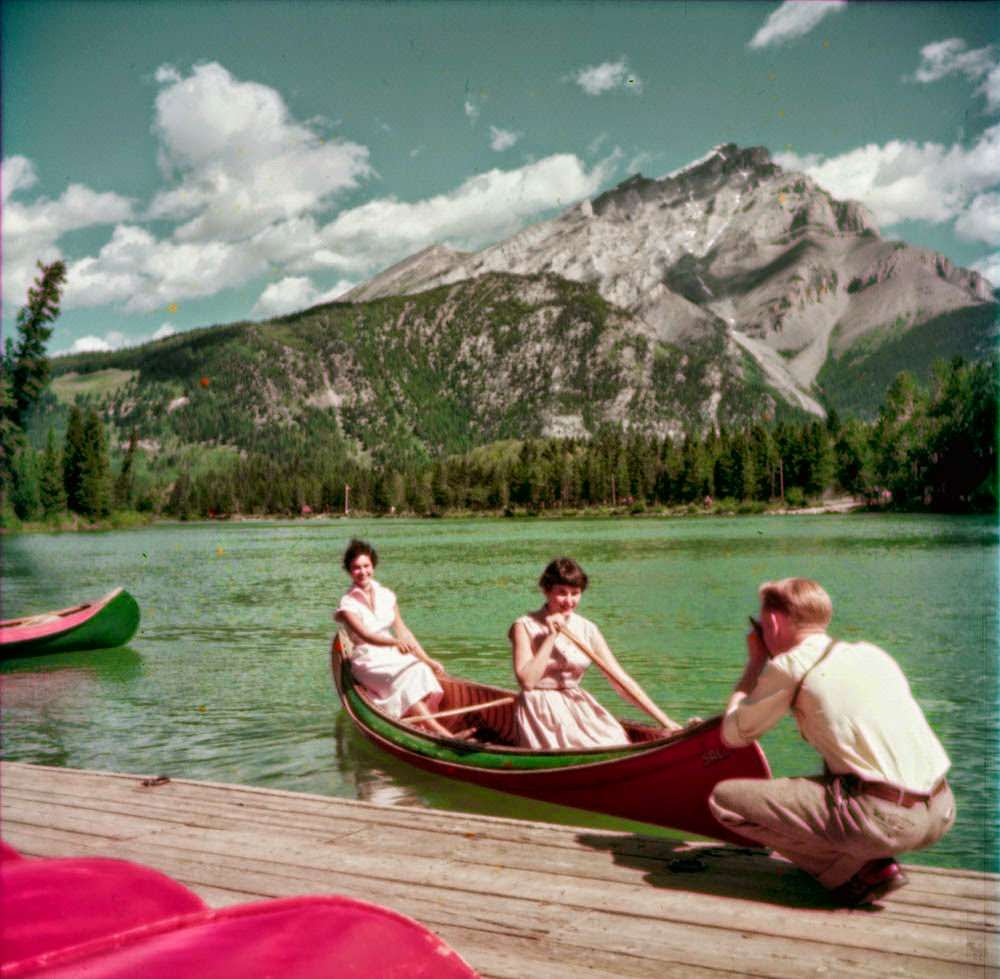 A man photographs two women in a canoe on the Bow River, 1952.