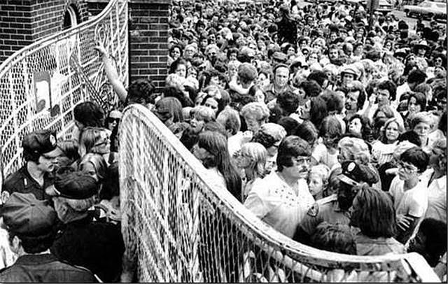 A crowd pushes toward the gates of Graceland Mansion in Memphis, to view the body of Elvis Presley.