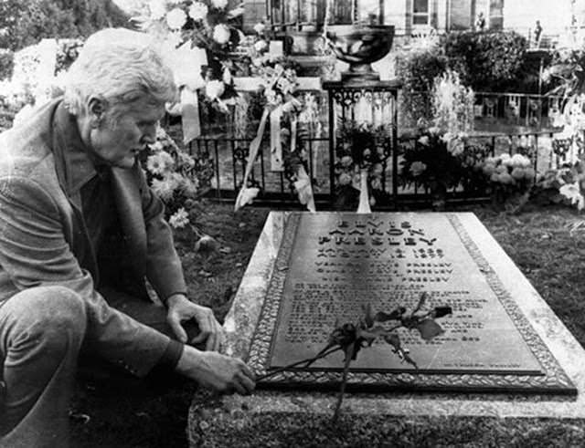 Vernon Presley, Elvis Presley's father, places a rose on his son's grave Nov. 24, 1977, as newspeople were permitted inside the grounds at Graceland in Memphis, Tenn., for the first time since Elvis' funeral.