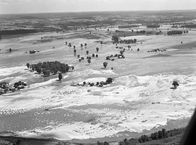 Aerial view of land covered with sand from receding flood waters, 1950