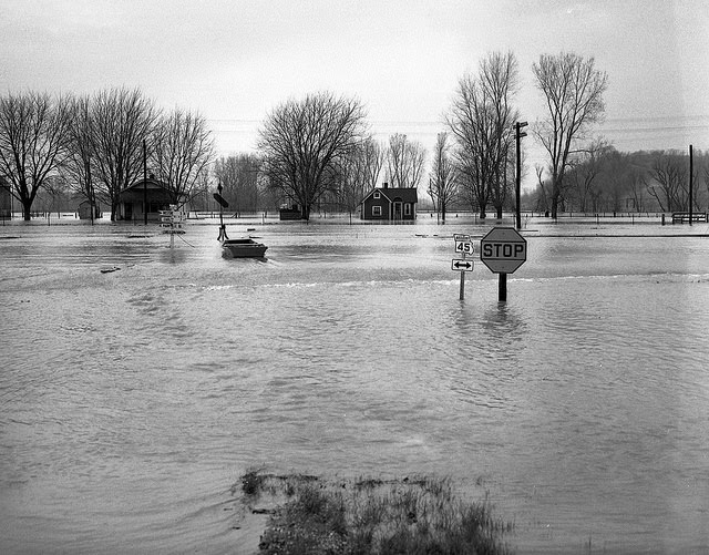Flooded intersection shows road signs partially submerged, 1951