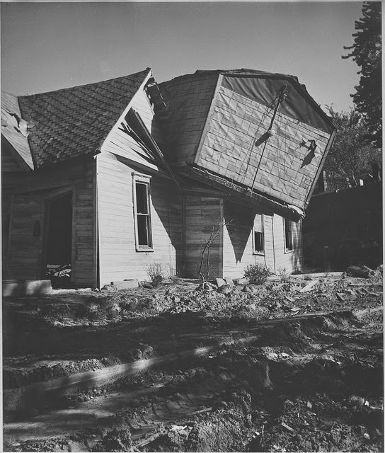 Aftermath of Kansas City flood shows one house deposited atop another house, 1951