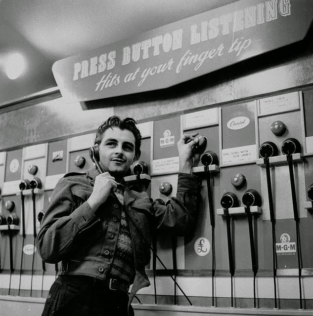 Customer using listening post, 1950s