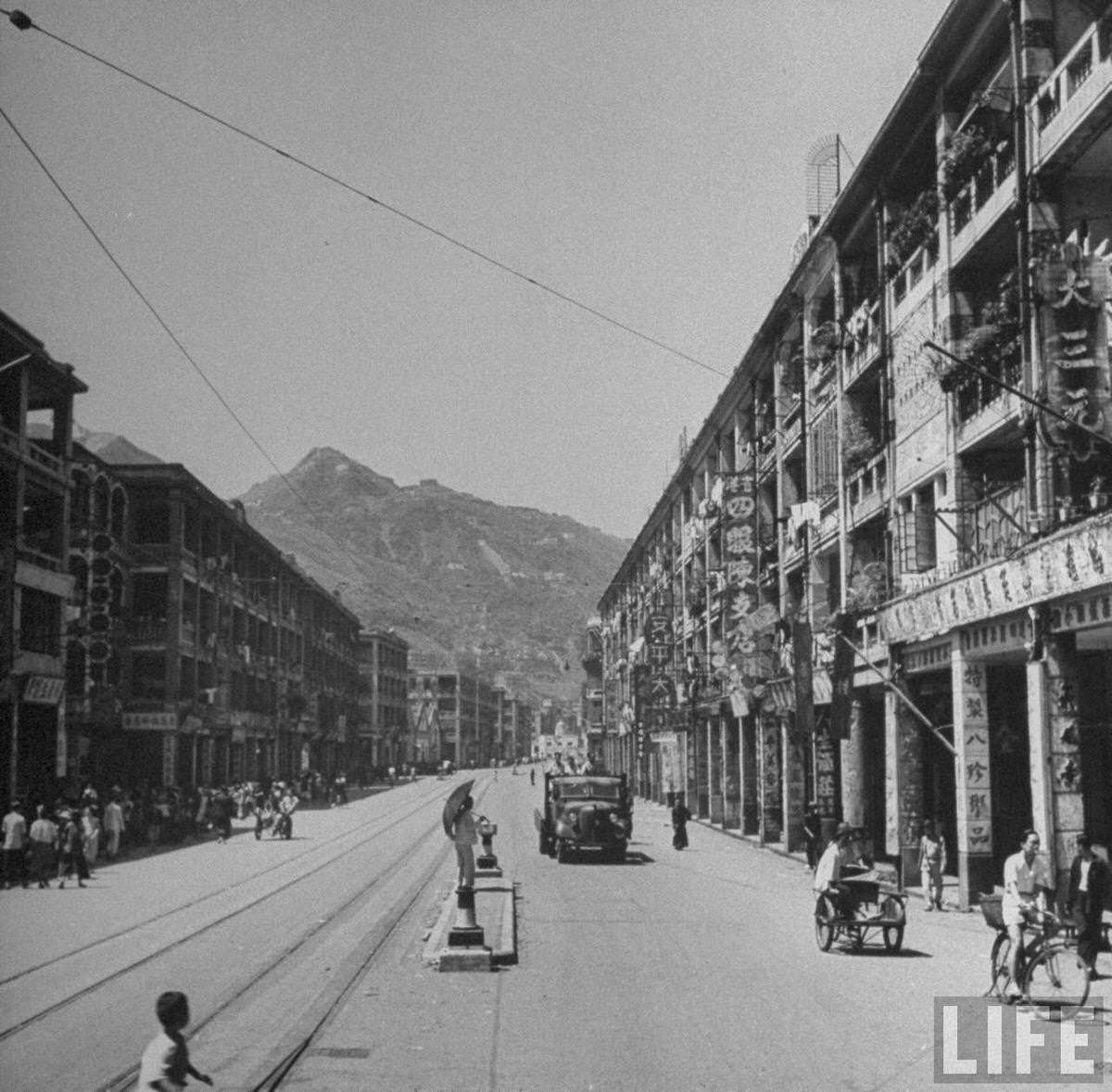 Pedestrians and vehicles moving along Queen's Road.