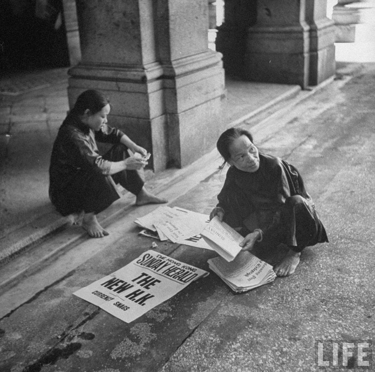 Chinese women selling newspapers.