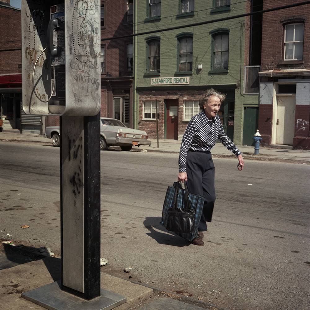 Woman walking in street, 1986