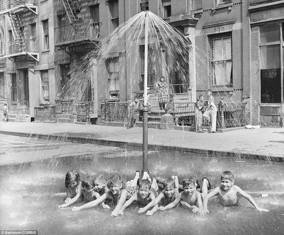 Children on East 101 Street, near Lexington Avenue play in a makeshift shower during 1948