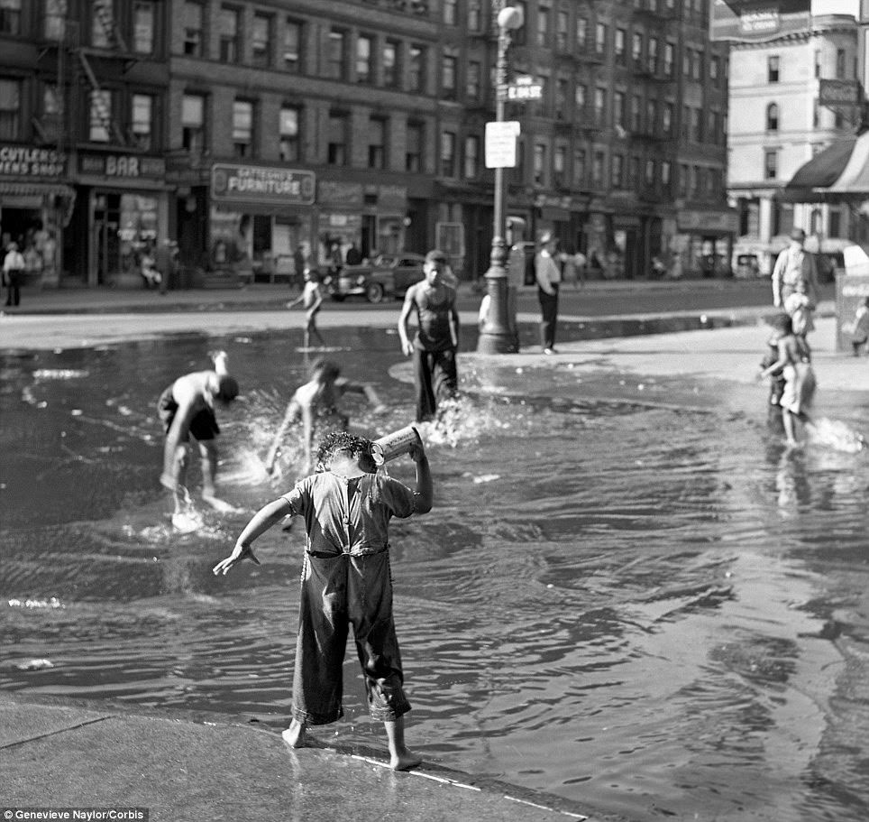 Dozens of children play in a water-filled 104th street in Harlem during 1939