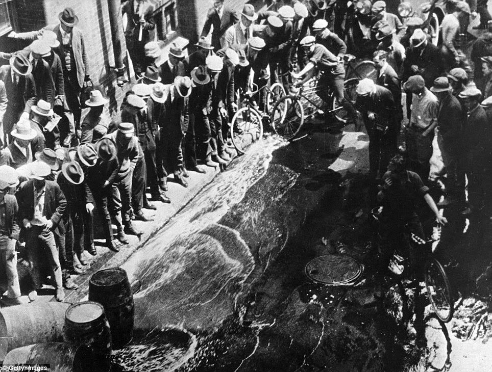 Counterfeit beer streams down a street after barrels were broken open