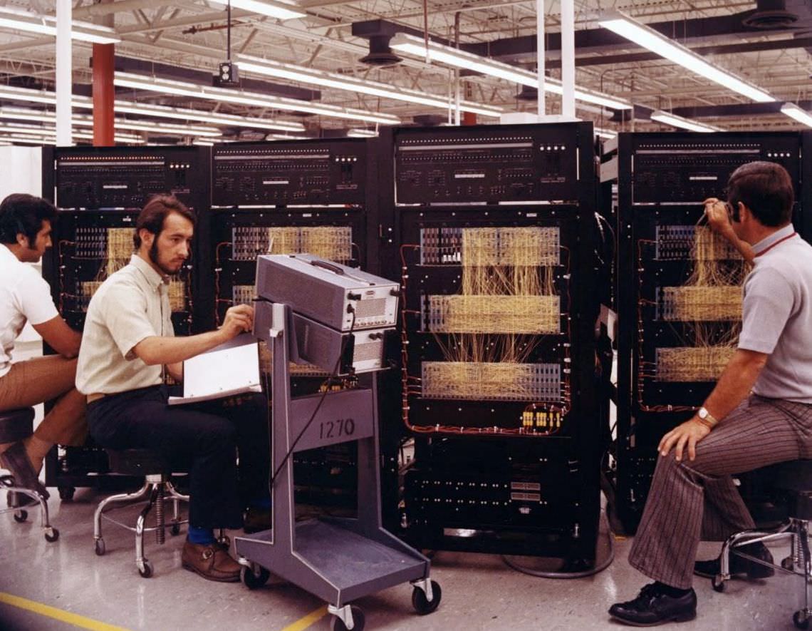 Three men working on circuit panels, 1965