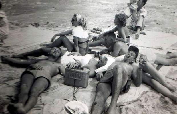 Beachgoers enjoying music on the radio at the beach in Wildwood, 1950s