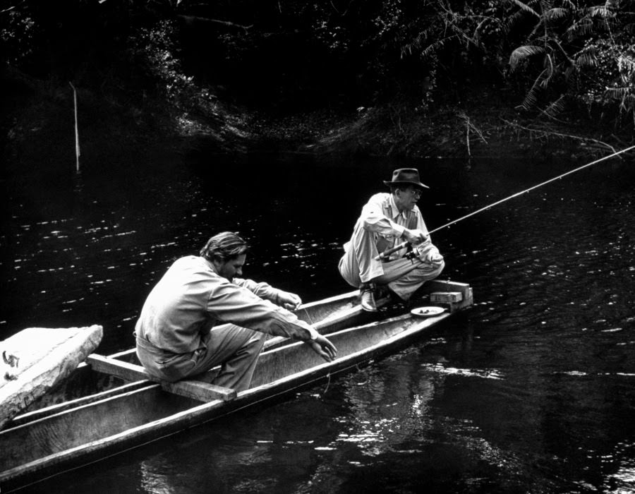 At siesta time after lunch everybody took it easy. Director Huston (right) fished doggedly with technician Kevin McClory, never caught a thing.