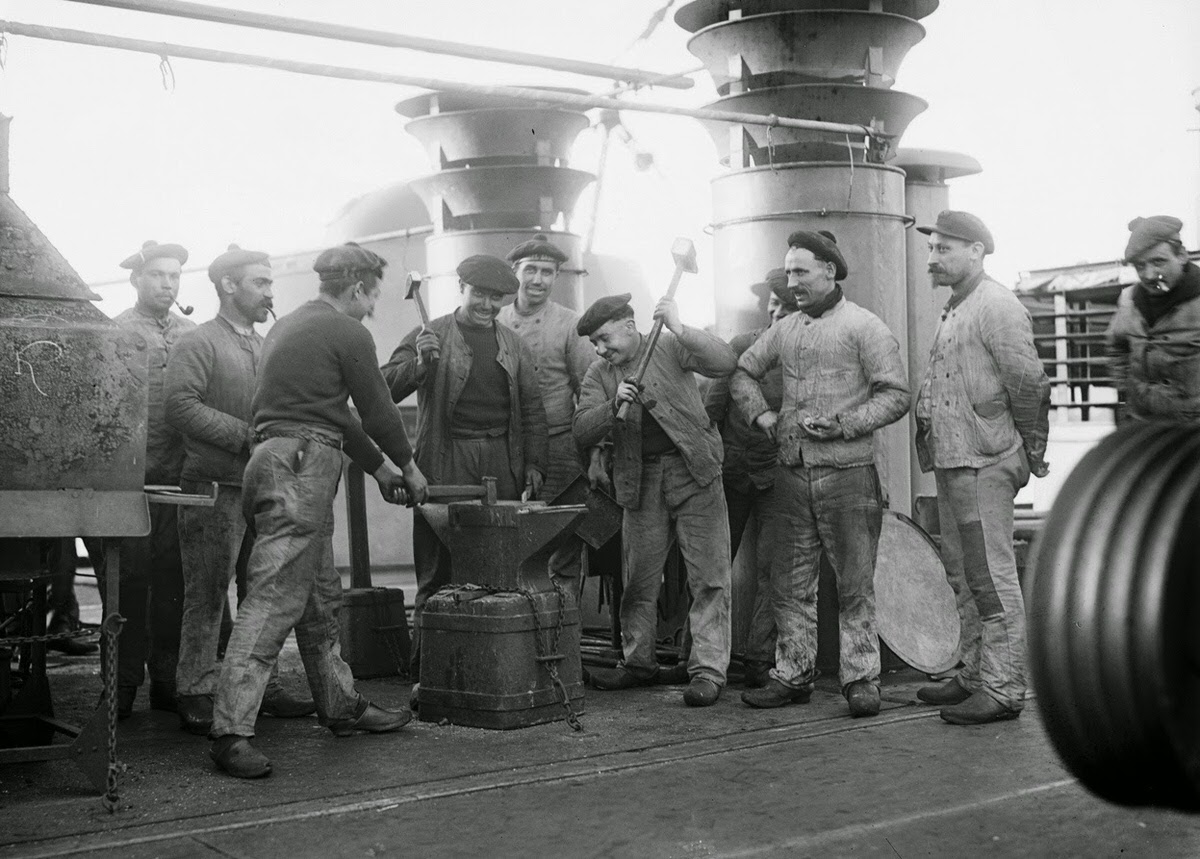 Sailors aboard the French cruiser Amiral Aube pose for a photograph at an anvil attached to the deck, 1918.