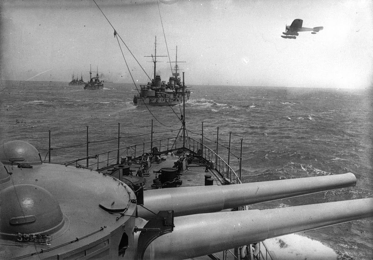 Allied warships at sea, a seaplane flyby, 1915.