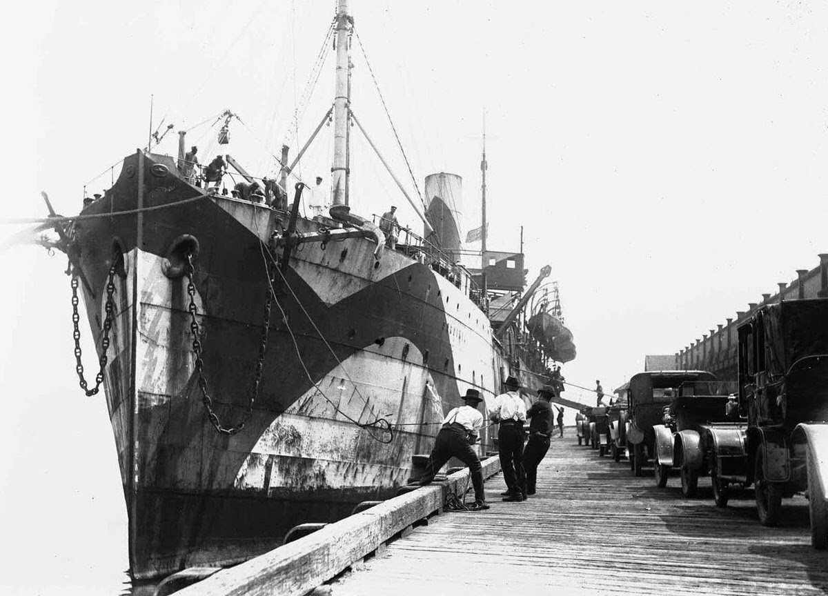 Troop transport Sardinia, in dazzle camouflage, at a wharf during World War I, 1918.