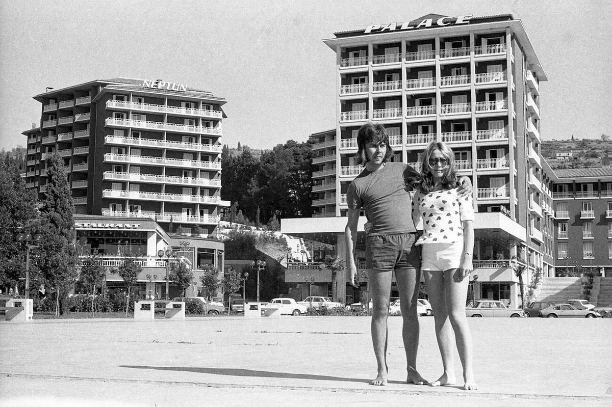 Young holiday couple in front of tourist hotels in Portoroz, Slovenia, 1972.