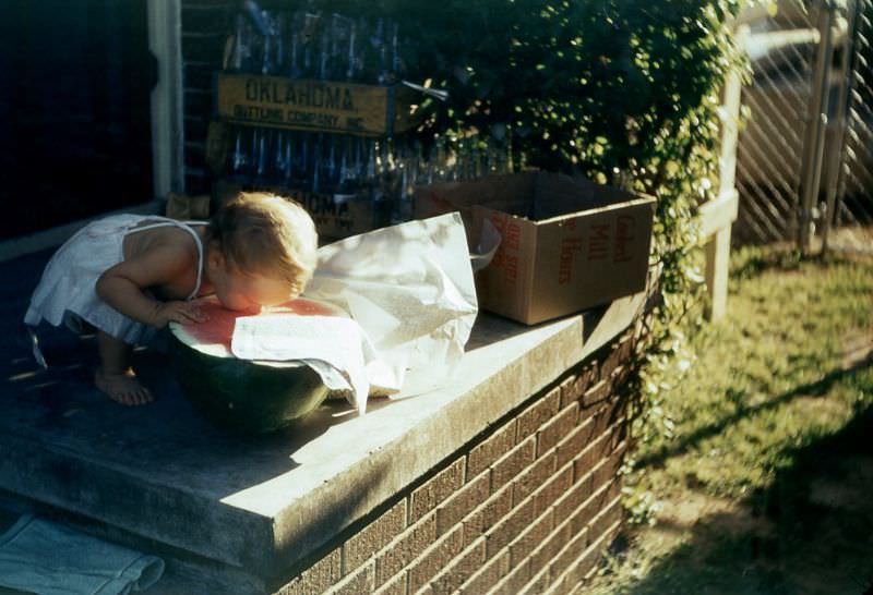 Child on a porch tasting watermelon, Oklahoma