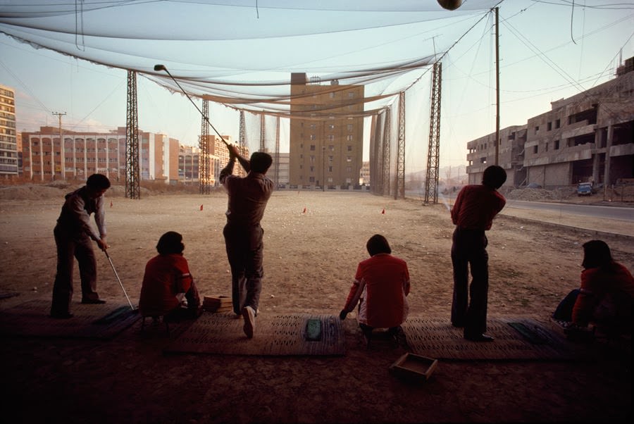 Temporary vacant lot serving as a driving range amid high-rise buildings, 1979