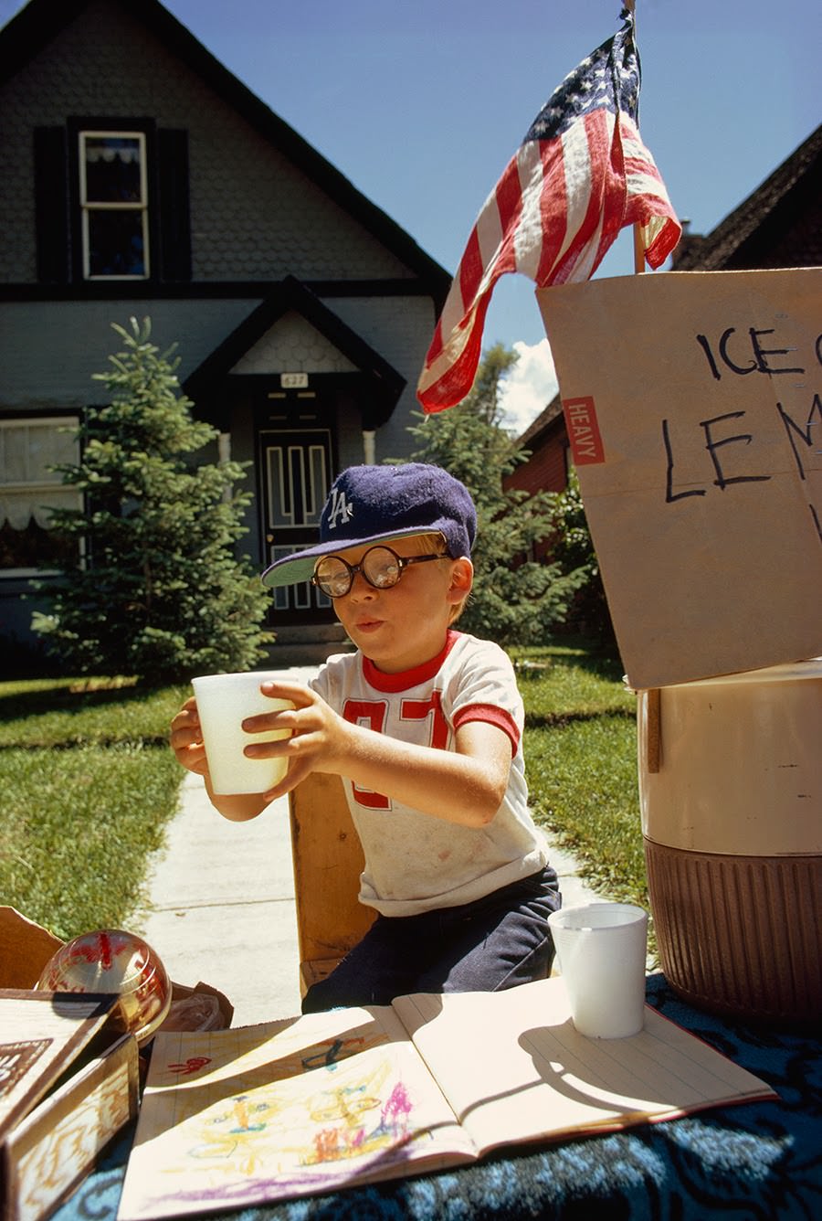 Boy selling lemonade from a front yard stand on Main Street in Aspen, Colorado, 1973