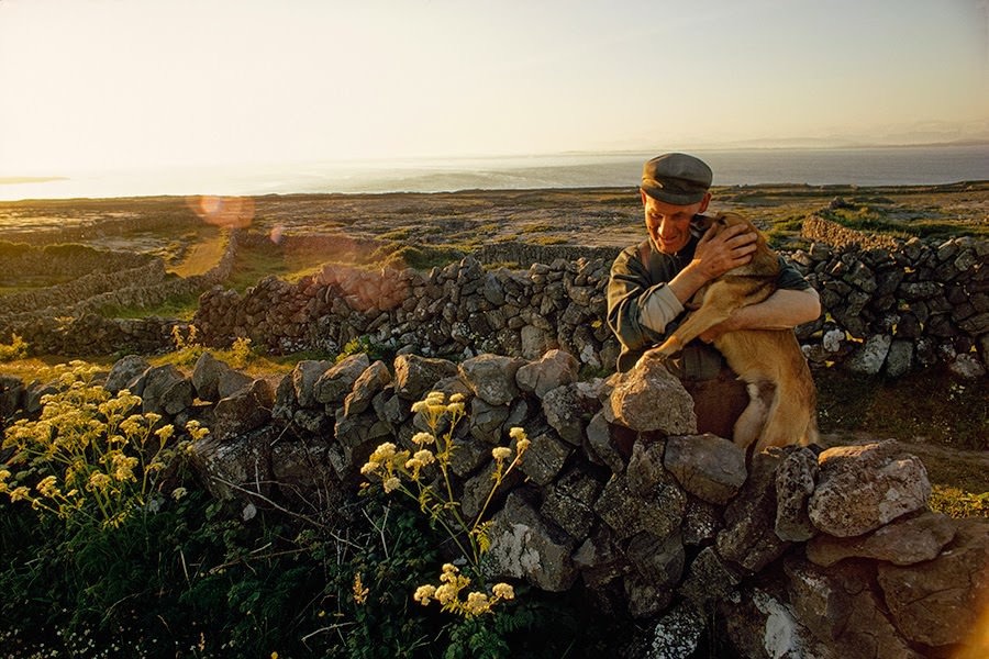 Farmer embracing his dog in a stonewalled field on Inishmore Island, Ireland, 1971