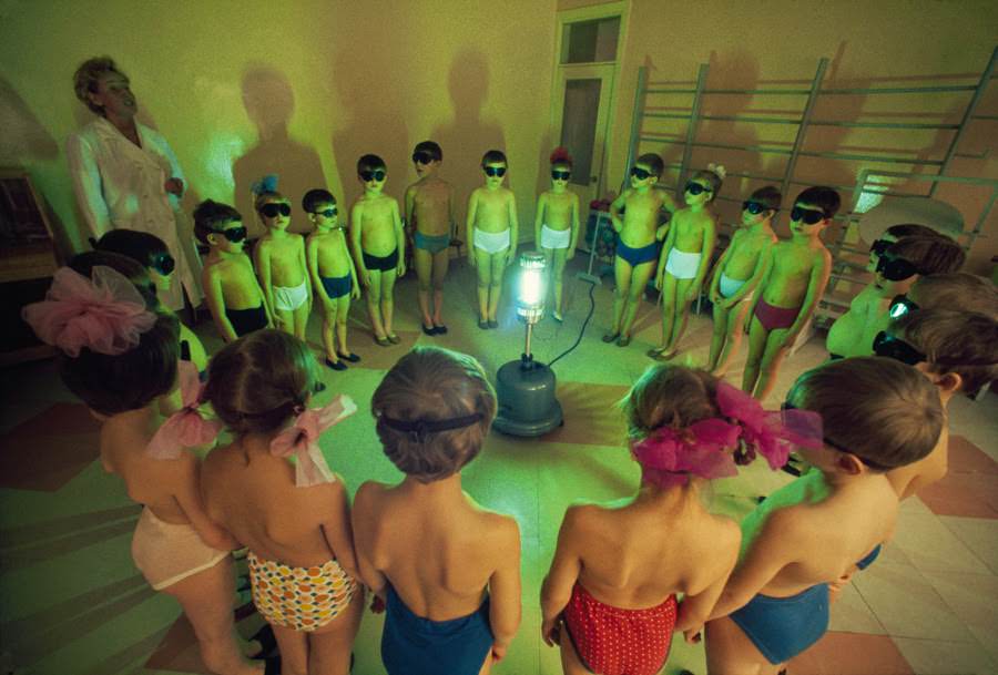 Children circling an ultraviolet lamp to receive vitamin D in Murmansk, Soviet Union, 1977