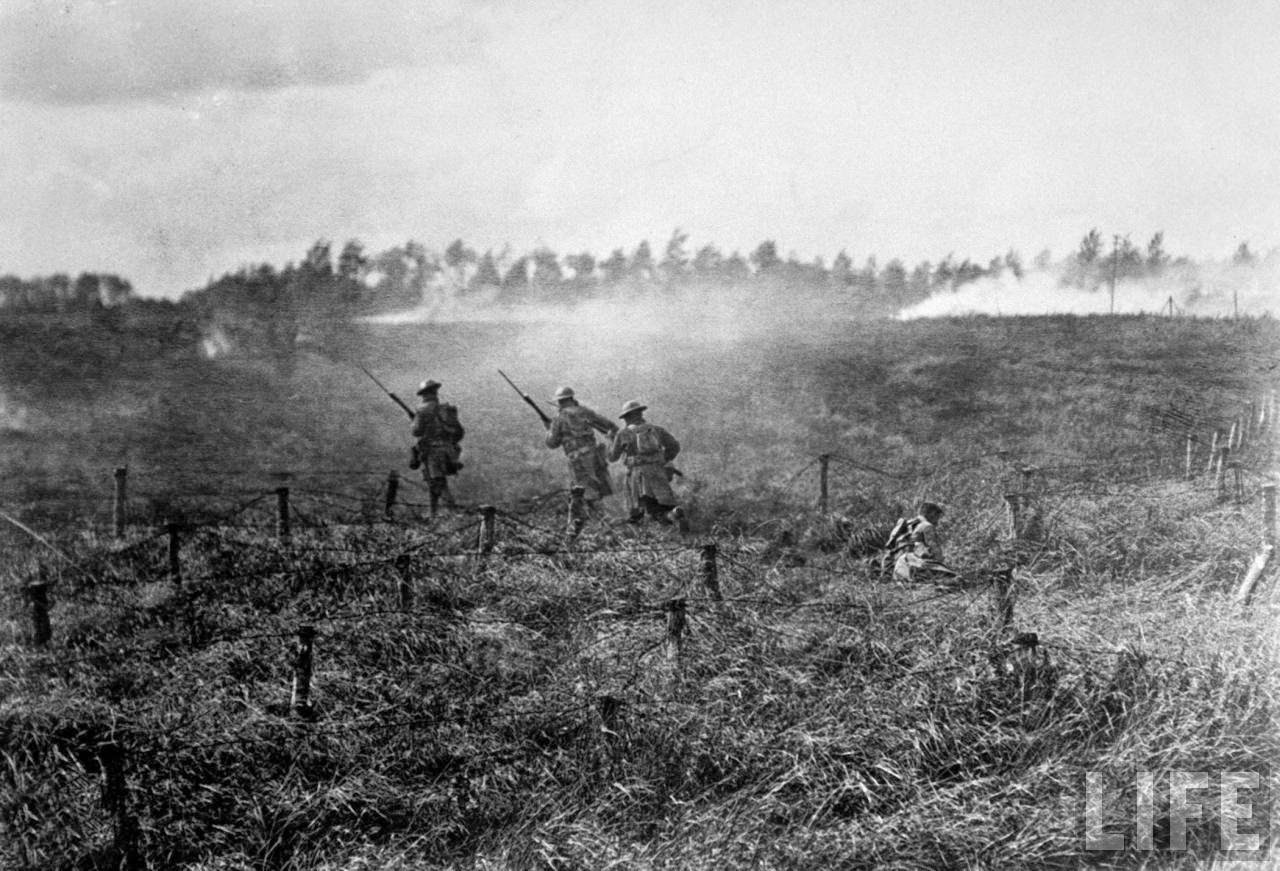 American troops running across a battlefield during World War I.