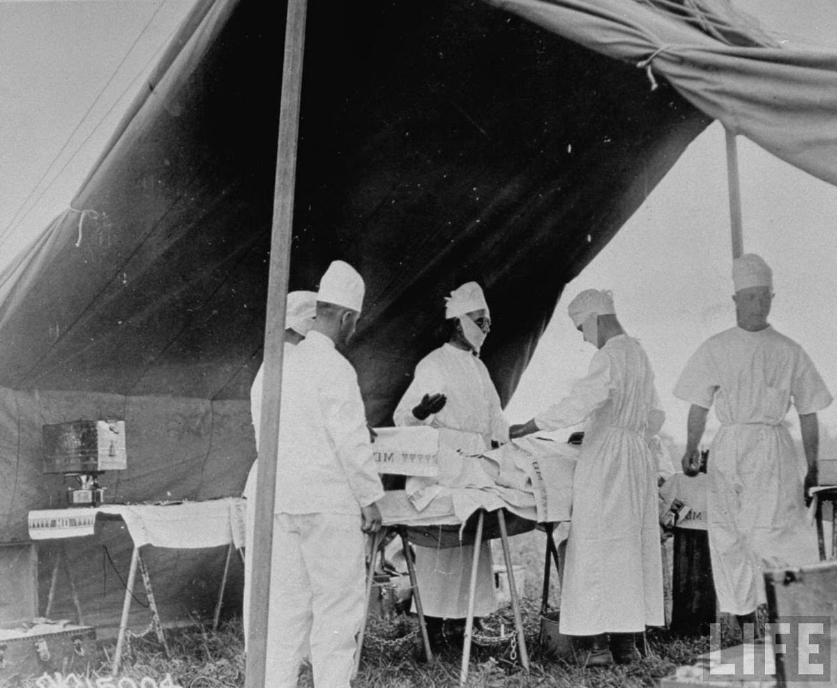 American surgeons giving aid to wounded in a field hospital during World War I.