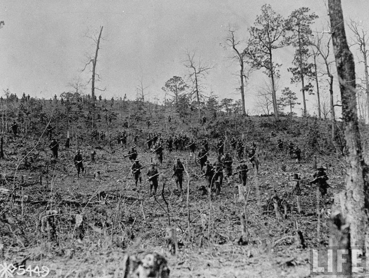 American troops moving through woodland shattered by artillery fire somewhere in France during World War I.