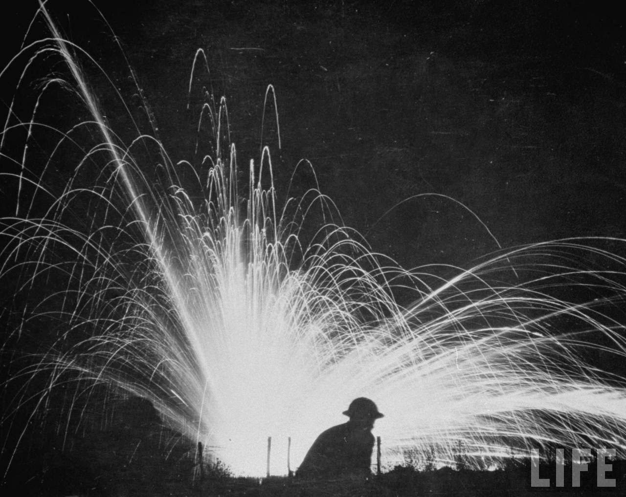 Allied soldier silhoutted by glare of an exploding German phosphorus bomb during World War I.