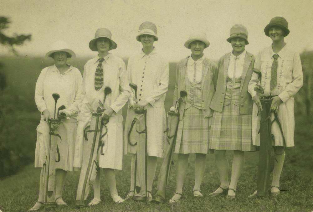 Young women wearing cloche hats and jackets with golf clubs, 1925