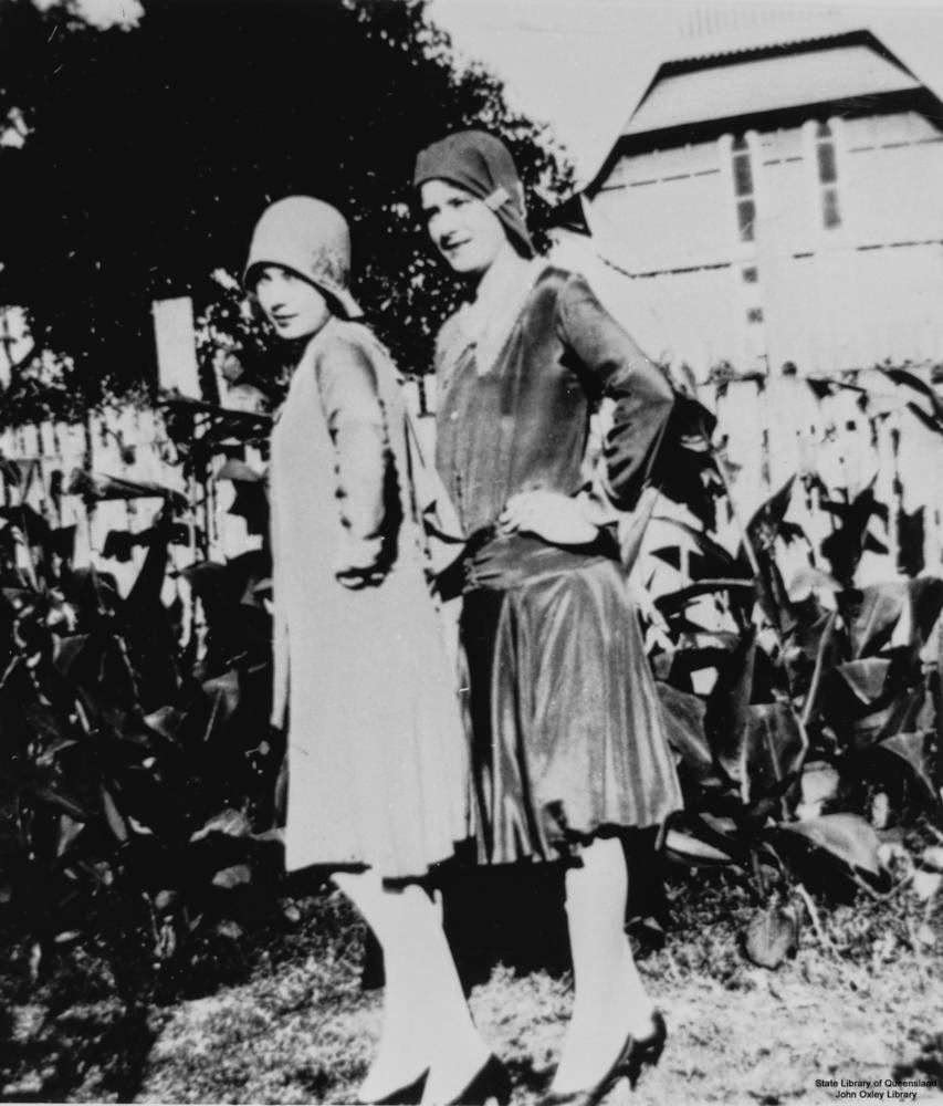 Two women wearing dresses with hip-line waistbands and hats, 1920s
