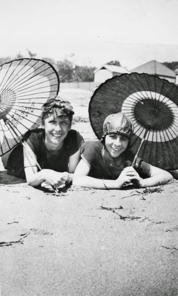 Beach girls posing under umbrellas in Brisbane, 1925