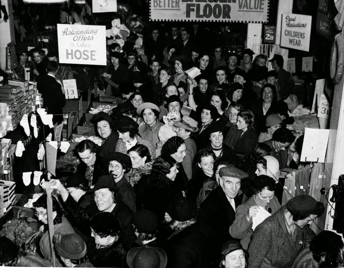 Crowds at a salvage sale in an east London department store using coupons to buy goods, 1941