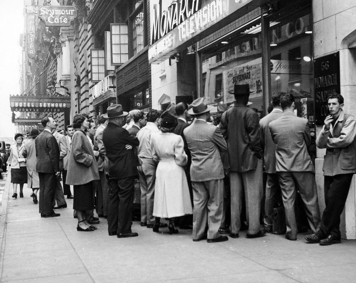 People looking in the window of an appliance store during a sale, 1945